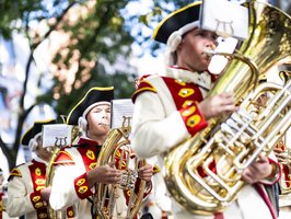 Volksfestumzug mit einem Spielmannszug, die auf ihren Instrumenten spielen.