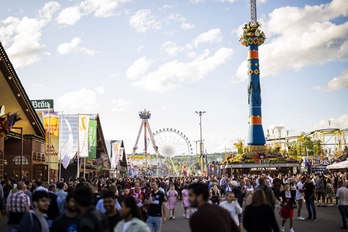 Unzählige Menschen laufen über die Wege des Cannstatter Volksfestes, vorbei an der Fruchtsäule