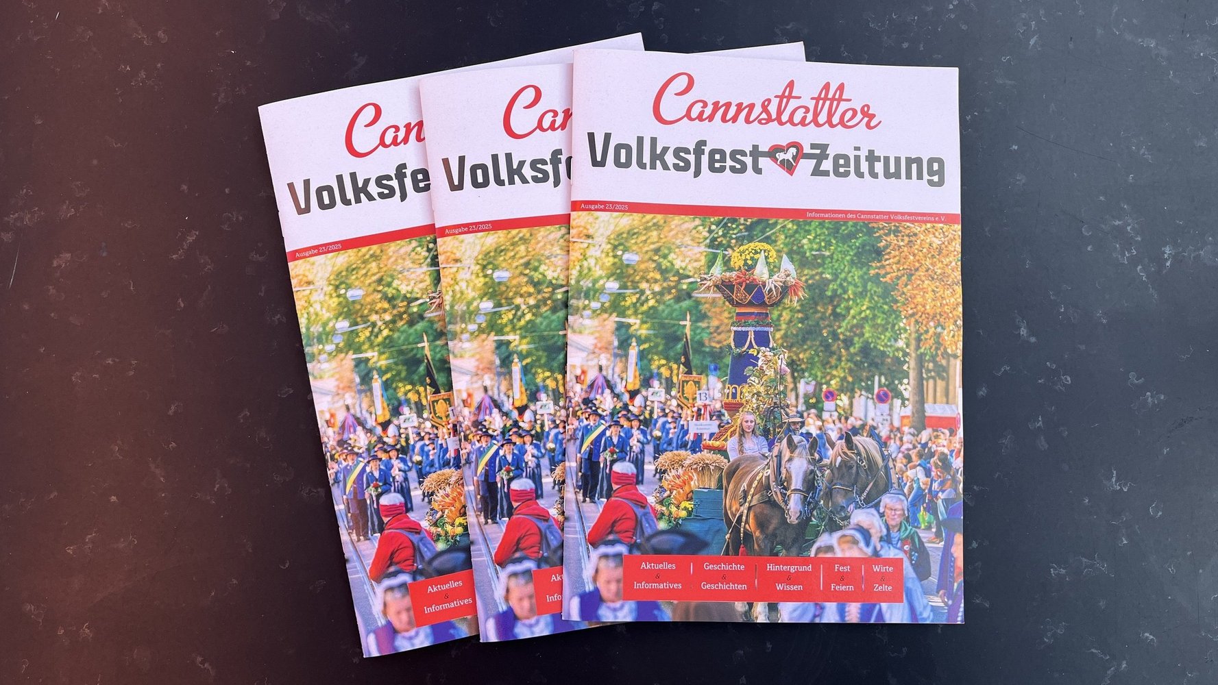 Drei aktuelle Ausgaben der Volksfestzeitung aufgefächert.