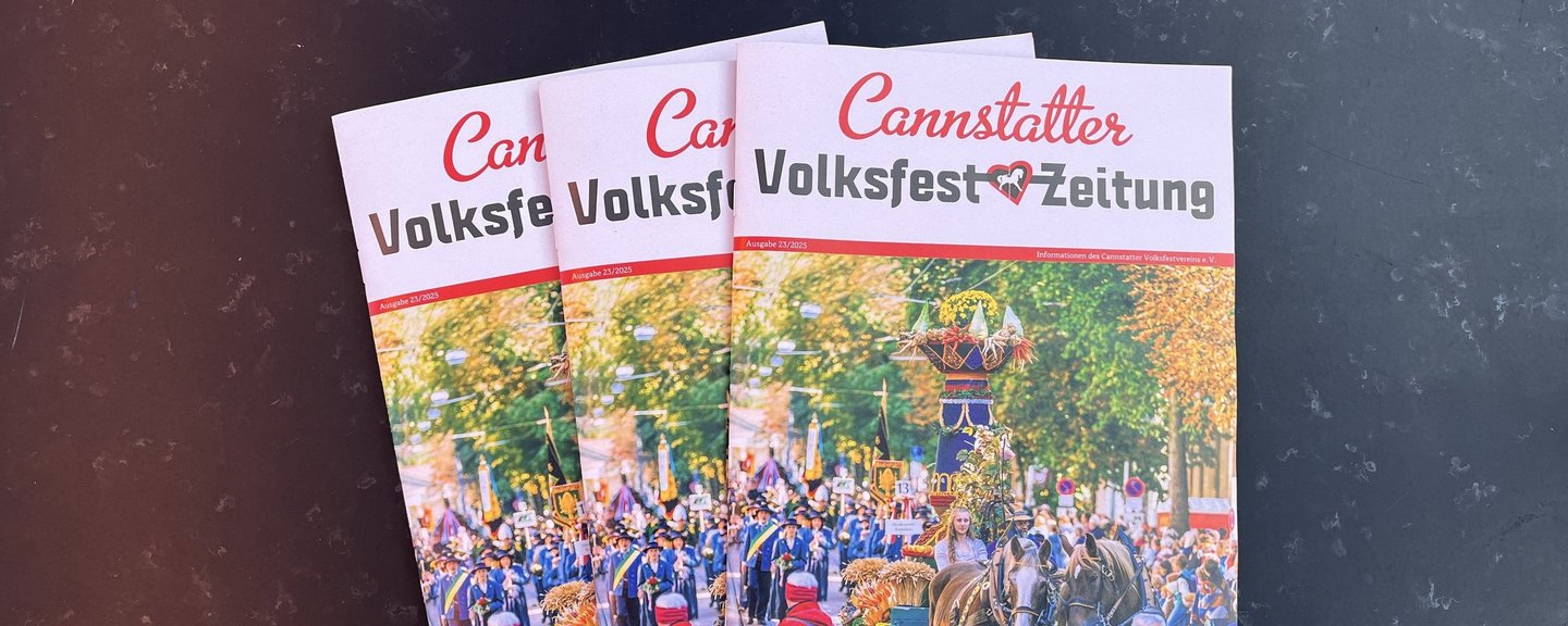 Drei Ausgaben der aktuellen Volksfestzeitung aufgefächert liegend.