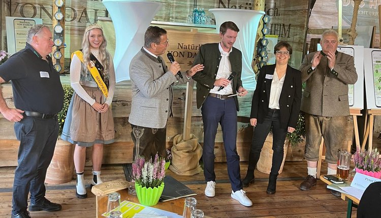 Der Podiumsdialog. Von links nach rechts stehen vor dem Podium: Markus Kaiser, Züchter von Bio-Weiderindern und Genussbotschafter, Linda Heinle – Bierkönigin von Baden-Württemberg und Produkthoheit, Minister Peter Hauk, Moderator Jonas Esterl, Sofie Masson, Brennerin und Genussbotschafterin und Karl Göbel