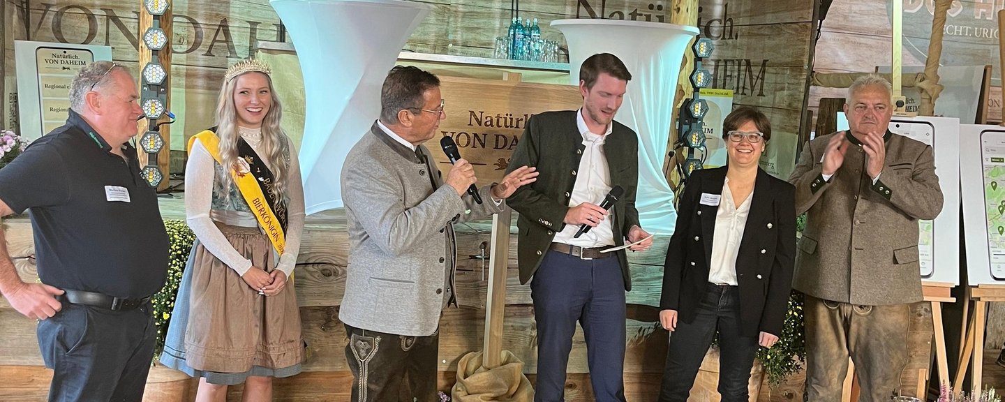 Der Podiumsdialog. Von links nach rechts stehen vor dem Podium: Markus Kaiser, Züchter von Bio-Weiderindern und Genussbotschafter, Linda Heinle – Bierkönigin von Baden-Württemberg und Produkthoheit, Minister Peter Hauk, Moderator Jonas Esterl, Sofie Masson, Brennerin und Genussbotschafterin und Karl Göbel