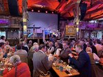 Vor der Bühne hinten im Bild steht Bürgermeister Thomas Fuhrmann. Davor sitzen an den Biertischen Schaustellerinnen und Schausteller und frühstücken.