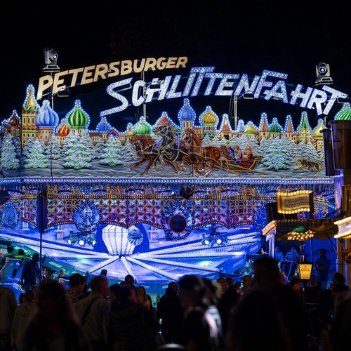Das Fahrgeschäft "Petersburger Schlittenfahrt" bei Dunkelheit komplett beleuchtet.