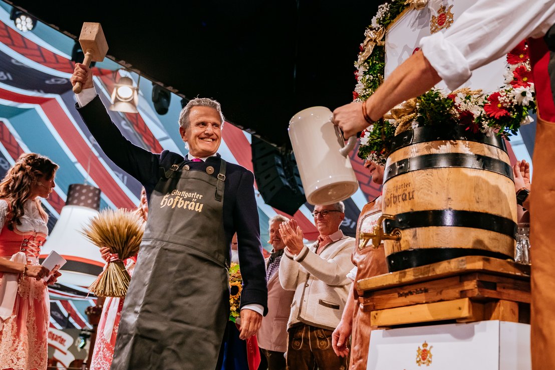 [Translate to English:] Oberbürgermeister Frank Nopper hebt den Ton-Krug nach dem erfolgreichen Fassanstich fröhlich in die Höhe.